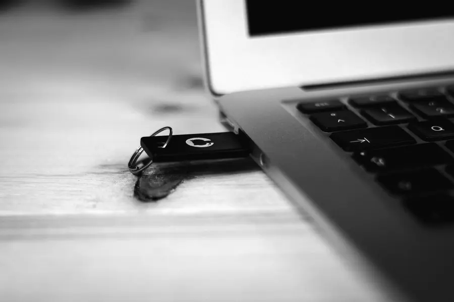 Clé USB branchée dans un ordinateur portable sur un bureau en bois