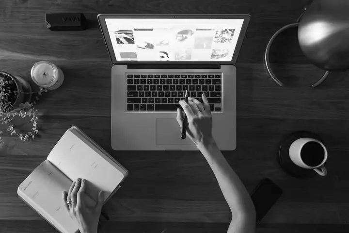 Designer au travail sur un ordinateur portable, sur un bureau en bois